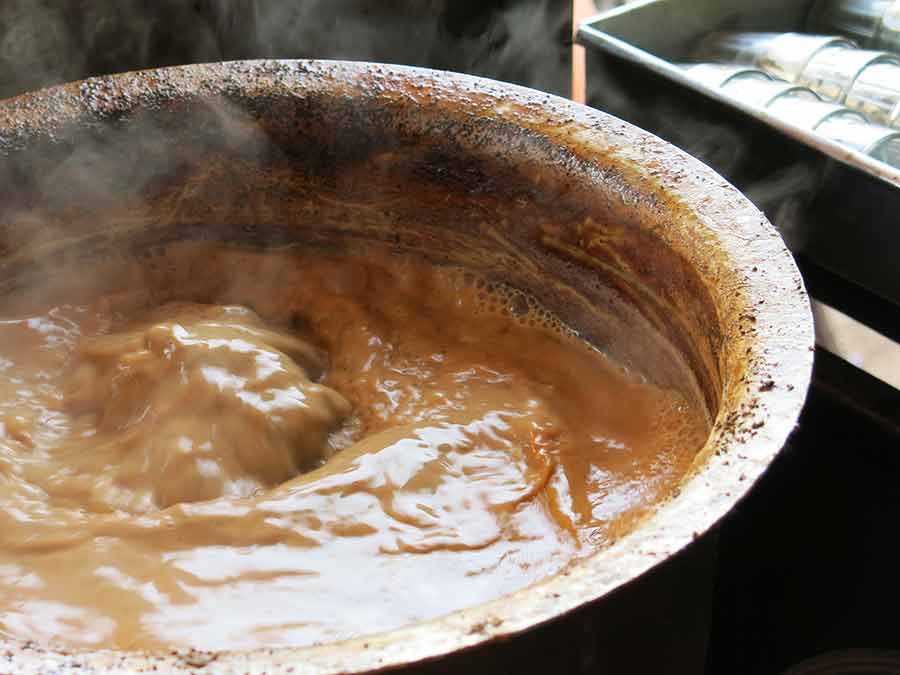 Une marmite de masala chaï bouillonne sur le stand de rue d'un chaï wallah (vendeur de thé).