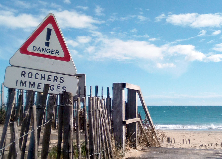 Panneau "danger, rochers immergés" sur la plage de Sète.